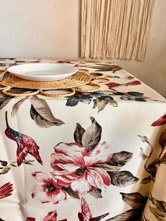 a white plate sitting on top of a table next to a flower covered table cloth