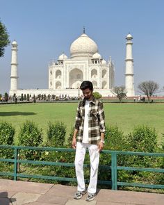 a man is standing in front of the taj muttrawaa mosque