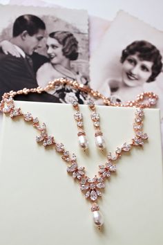 an image of wedding jewelry on display with pictures in the back ground and behind it