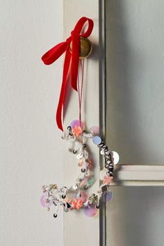 a door handle decorated with charms and a red ribbon hanging from it's side