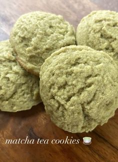 four green cookies sitting on top of a wooden table