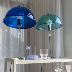 two blue lamps sitting on top of a white table