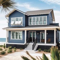 a blue house on the beach with stairs leading up to it's second floor