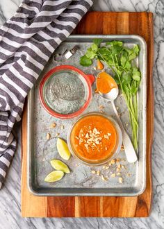 the ingredients to make an orange sauce are on a tray with spoons and lemon wedges