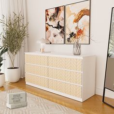 a white dresser sitting next to a tall mirror on top of a hard wood floor