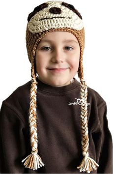 a little boy wearing a crocheted hat and smiling