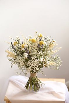 a vase filled with lots of white and yellow flowers