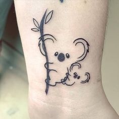 a small koala bear tattoo on the ankle with an arrow in it's mouth