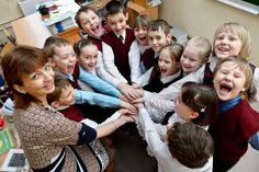 a group of children are holding hands in the middle of a circle and smiling at the camera