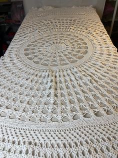 a white crocheted bedspread with an intricate design on the bottom and sides