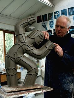 a man is working on a sculpture in his studio