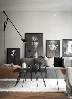 a living room filled with furniture and pictures on the wall next to a coffee table