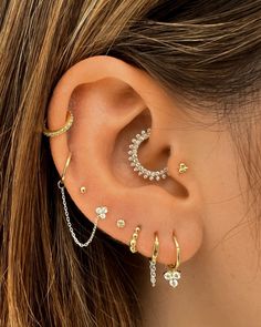 a woman's ear with multiple piercings on it