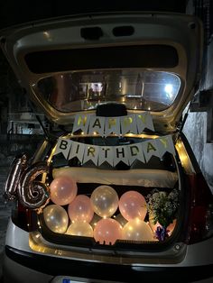 the trunk of a car is decorated with balloons and streamers that say happy birthday