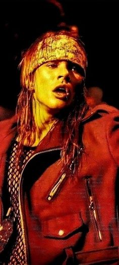 a man with long hair wearing a red leather jacket and bandanna on his head