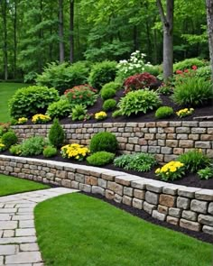 a stone retaining wall with flowers and trees in the background