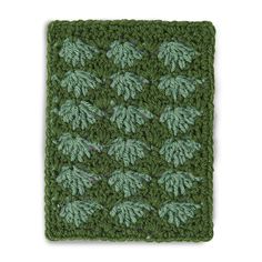 a crocheted square with green leaves on it