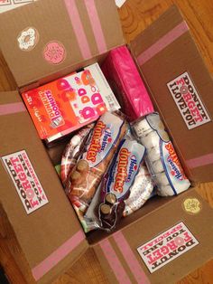 an open box filled with snacks on top of a wooden floor