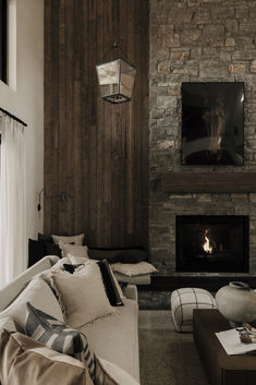 a living room filled with furniture and a fire place in front of a stone fireplace