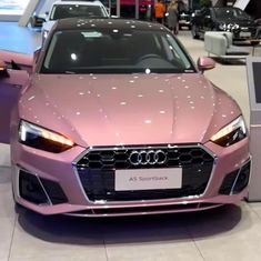 a pink car is on display at an auto show