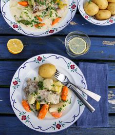 two plates with different types of food on them next to some lemons and potatoes