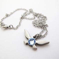 a silver necklace with a blue crystal in the center