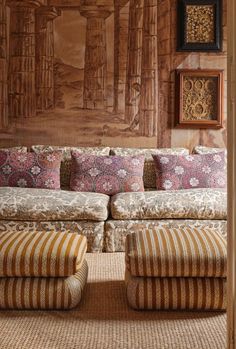 a living room filled with lots of furniture and pillows on top of a rug covered floor