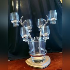 a glass candle holder with six candles in it