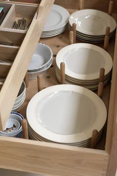 an open drawer with plates and bowls in it