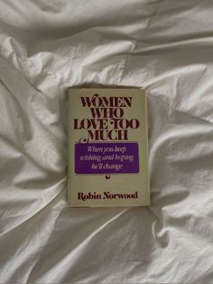 the book women who love too much is laying on a bed with white sheets and pillows