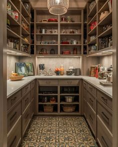 a kitchen with lots of wooden cupboards and shelves filled with food, drinks and utensils