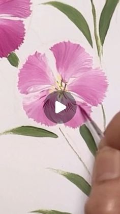 someone is painting flowers on the wall with watercolors