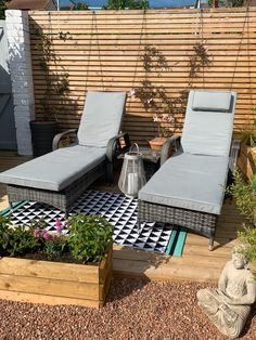 two lounge chairs sitting on top of a wooden deck