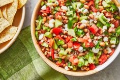 a bowl filled with beans and veggies next to some tortilla chips