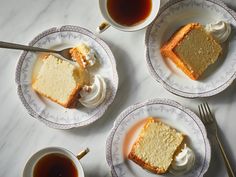 three plates with slices of cake on them next to a cup of tea and fork