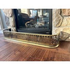 a fireplace with a fire place sitting on top of a hard wood floor next to a stone wall