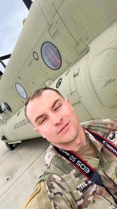 a man in uniform standing next to an airplane