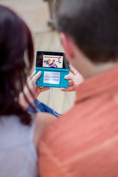 a man and woman looking at an electronic device