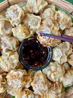 a bowl filled with dumplings and dipping sauce