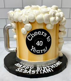 a birthday cake made to look like a beer mug with white flowers on top and cheers 40 years written on the side