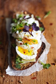 an open face sandwich topped with hard boiled eggs and greens