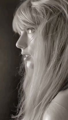 a black and white photo of a woman with long hair looking off to the side