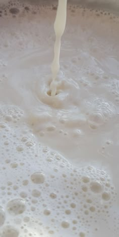 milk being poured into a pan with bubbles on the bottom and in the middle, as seen from above