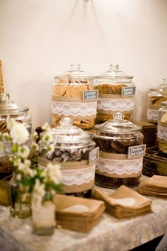 several glass jars filled with cookies on top of a table