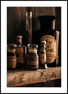 an old wooden shelf with jars and bottles on it, including one for the spice grinder