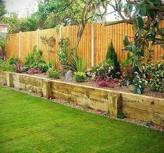 a garden with wooden fence and green grass