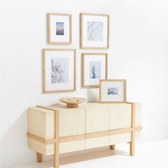 a white wall with pictures on it next to a dresser