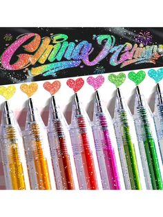 the glitter pens are lined up in front of a sign with hearts and stars on it