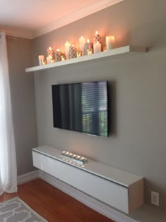 a flat screen tv sitting on top of a white shelf