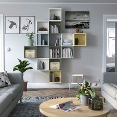 a living room filled with furniture and bookshelves next to a wall mounted book shelf